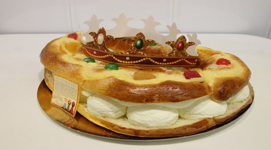 Corte de roscón de reyes artesanal mostrando el relleno de nata y la miga esponjosa